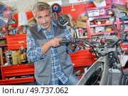 a worker fixing a motorbike. Стоковое фото, агентство Ingram Publishing / Фотобанк Лори