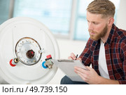 professional electrician man is fixing a water heater. Стоковое фото, агентство Ingram Publishing / Фотобанк Лори