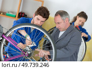 two mechanics in a bike repair station. Стоковое фото, агентство Ingram Publishing / Фотобанк Лори