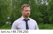 Confident Businessman in Natural Setting. Man stands in front of lush green backdrop. Remote working. Portrait of happy mid adult male wearing formal clothes, shirt and tie, glasses. Find inspiration. Стоковое видео, видеограф Марина Демидюк / Фотобанк Лори
