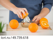 woman squeezing an orange fruit. Стоковое фото, агентство Ingram Publishing / Фотобанк Лори