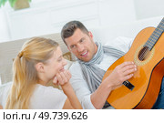 Man playing guitar to lady. Стоковое фото, агентство Ingram Publishing / Фотобанк Лори