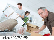 tired dad helping daughter and boyfriend moving houses. Стоковое фото, агентство Ingram Publishing / Фотобанк Лори