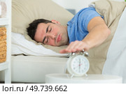man turning off his alarm clock. Стоковое фото, агентство Ingram Publishing / Фотобанк Лори