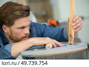 concentrated man in fixing a chair. Стоковое фото, агентство Ingram Publishing / Фотобанк Лори