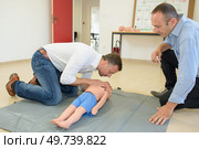 Man practicing resuscitation on a child dummy. Стоковое фото, агентство Ingram Publishing / Фотобанк Лори