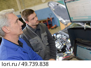 student with instructor repairing a car during apprenticeship. Стоковое фото, агентство Ingram Publishing / Фотобанк Лори