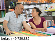 a couple discussing wallpaper rolls. Стоковое фото, агентство Ingram Publishing / Фотобанк Лори