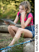 young female hiker sitting while looking at a map. Стоковое фото, агентство Ingram Publishing / Фотобанк Лори