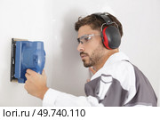 man with plastic glasses sanding a wall. Стоковое фото, агентство Ingram Publishing / Фотобанк Лори