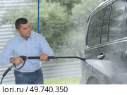 mature man washing his 4x4 at the station. Стоковое фото, агентство Ingram Publishing / Фотобанк Лори