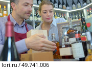 Wine merchant showing presentation packs to customer. Стоковое фото, агентство Ingram Publishing / Фотобанк Лори