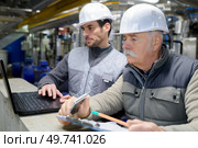 colleagues wearing hard hats checking document. Стоковое фото, агентство Ingram Publishing / Фотобанк Лори
