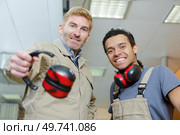 portrait of two workmen with earmuffs. Стоковое фото, агентство Ingram Publishing / Фотобанк Лори