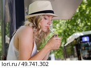 woman sat in busstop lighting a cigarette. Стоковое фото, агентство Ingram Publishing / Фотобанк Лори