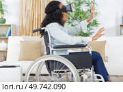 woman in wheelchair wearing virtual reality goggles. Стоковое фото, агентство Ingram Publishing / Фотобанк Лори