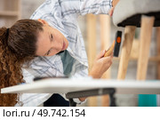 beautiful young woman repairing a chair. Стоковое фото, агентство Ingram Publishing / Фотобанк Лори