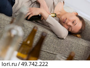 alcoholic woman sleeping holding the bottles. Стоковое фото, агентство Ingram Publishing / Фотобанк Лори