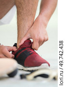 sportsman tucking lace inside his trainers. Стоковое фото, агентство Ingram Publishing / Фотобанк Лори