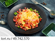 Homemade pasta with roasted bacon, pasta carbonara served on a black plate.. Spaghetti pasta dish with bacon and cheese. Стоковое фото, агентство Ingram Publishing / Фотобанк Лори