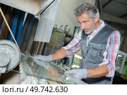 a man manufacturing of glass windows. Стоковое фото, агентство Ingram Publishing / Фотобанк Лори