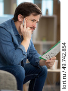 young man doing a crossword puzzle. Стоковое фото, агентство Ingram Publishing / Фотобанк Лори