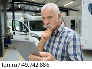 caravan dealer looking at his tablet. Стоковое фото, агентство Ingram Publishing / Фотобанк Лори