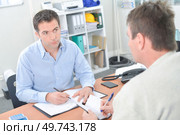Two men sat at desk with their diaries open. Стоковое фото, агентство Ingram Publishing / Фотобанк Лори