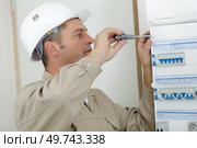 electrician securing cover of fusebox with a screwdriver. Стоковое фото, агентство Ingram Publishing / Фотобанк Лори
