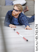 blind man has fallen on the floor at home. Стоковое фото, агентство Ingram Publishing / Фотобанк Лори