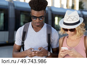 stupefied two mixed couple stares at smart phone. Стоковое фото, агентство Ingram Publishing / Фотобанк Лори