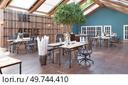 A large open office space with wooden floors . The space is filled with desks and chairs, and there are several potted plants scattered throughout the room. A large open office space with wooden floors. Стоковое фото, агентство Ingram Publishing / Фотобанк Лори