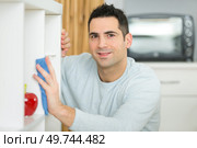 portrait of man dusting at home. Стоковое фото, агентство Ingram Publishing / Фотобанк Лори