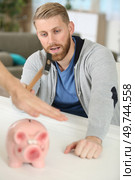 hand preventing man from smashing piggy bank with a hammer. Стоковое фото, агентство Ingram Publishing / Фотобанк Лори