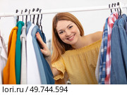 portrait of a pretty girl looking trough the wardrobe. Стоковое фото, агентство Ingram Publishing / Фотобанк Лори