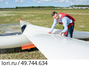 Pilot looking at wing of sailplane. Стоковое фото, агентство Ingram Publishing / Фотобанк Лори