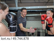 two female boxers training with male coach. Стоковое фото, агентство Ingram Publishing / Фотобанк Лори