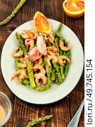 Roast asparagus with fried prawns on rustic wooden table.. Asparagus stir fried with shrimp. Стоковое фото, агентство Ingram Publishing / Фотобанк Лори