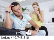 lady chuckling as her boyfriend struggles to close suitcase. Стоковое фото, агентство Ingram Publishing / Фотобанк Лори