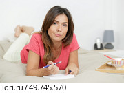 woman layed on bed pondering over her list. Стоковое фото, агентство Ingram Publishing / Фотобанк Лори