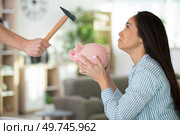 sorrowful woman not wanting to smash her piggybank. Стоковое фото, агентство Ingram Publishing / Фотобанк Лори