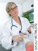female doctor bandaging male hand sprained wrist. Стоковое фото, агентство Ingram Publishing / Фотобанк Лори