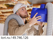 young male contractor installing an air conditioning unit. Стоковое фото, агентство Ingram Publishing / Фотобанк Лори