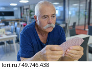 senior men playing cards outdoors. Стоковое фото, агентство Ingram Publishing / Фотобанк Лори