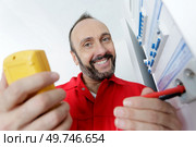 electrician measurements with multimeter tester in control panel. Стоковое фото, агентство Ingram Publishing / Фотобанк Лори