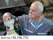 senior welder setting gas bottle before welding. Стоковое фото, агентство Ingram Publishing / Фотобанк Лори