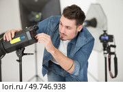 photographer controlling the studio flash strobe lighting head. Стоковое фото, агентство Ingram Publishing / Фотобанк Лори