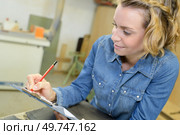 charismatic technician taking notes in the workshop. Стоковое фото, агентство Ingram Publishing / Фотобанк Лори