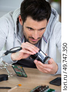 electrician working with electronical devices to the camera. Стоковое фото, агентство Ingram Publishing / Фотобанк Лори