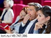 man yawning while watching film in cinema. Стоковое фото, агентство Ingram Publishing / Фотобанк Лори
